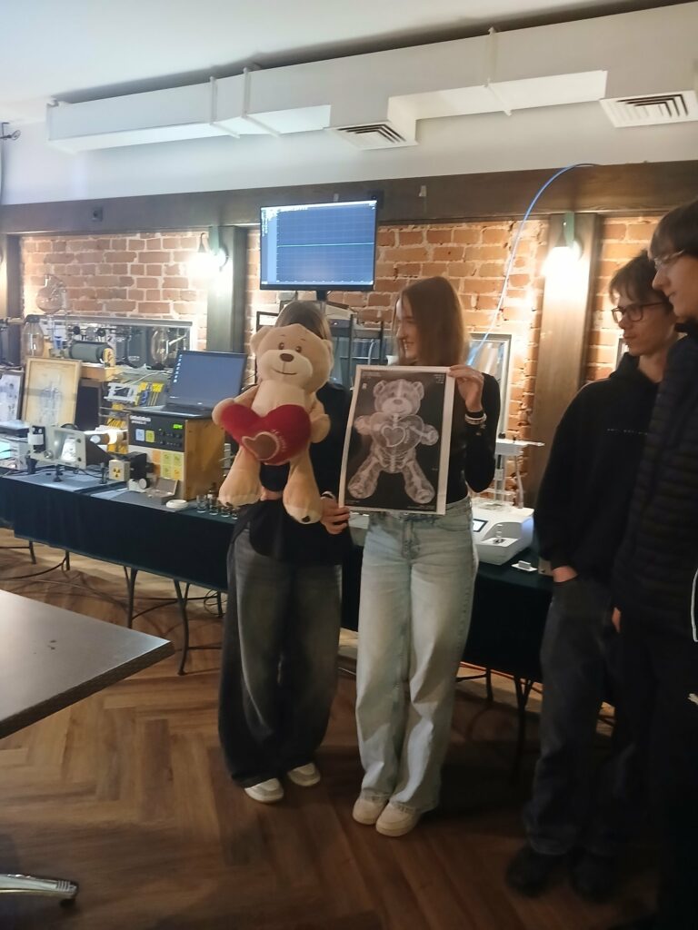 Uczennice prezentują zdjęcie rentgenowskie pluszowego misia wykonane podczas Wieczoru Nauki